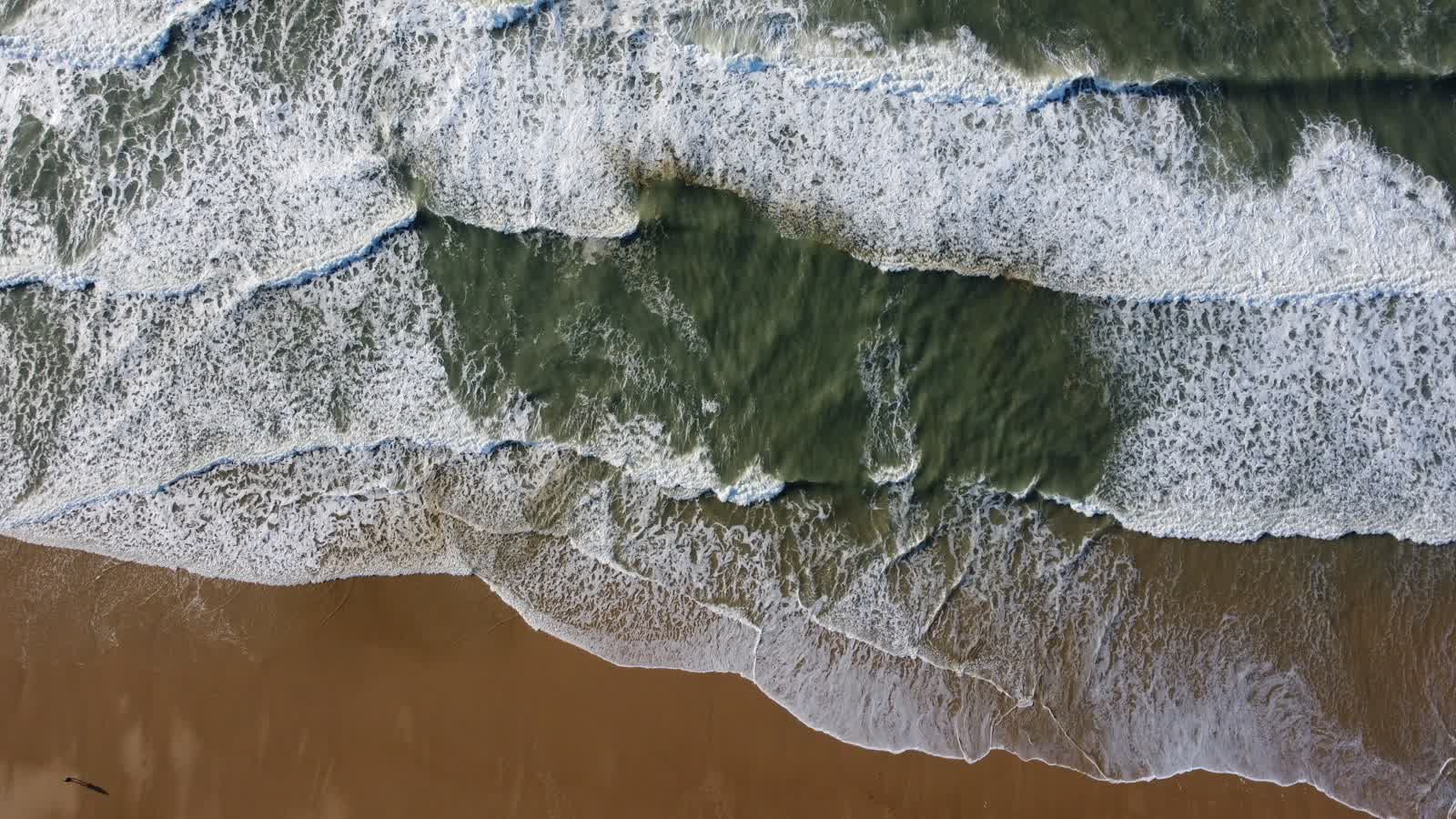 Vagues sur une plage de sable vues du ciel