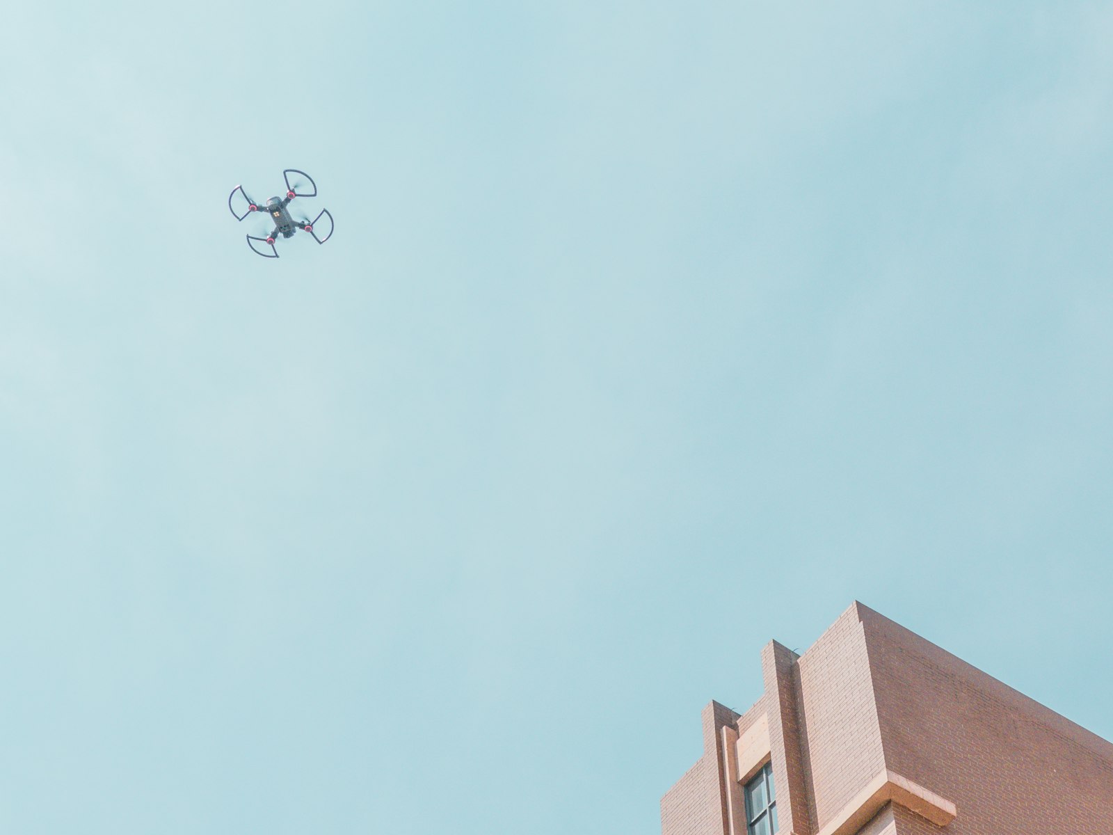 Drone en vol près de la façade d'un bâtiment pour inspection